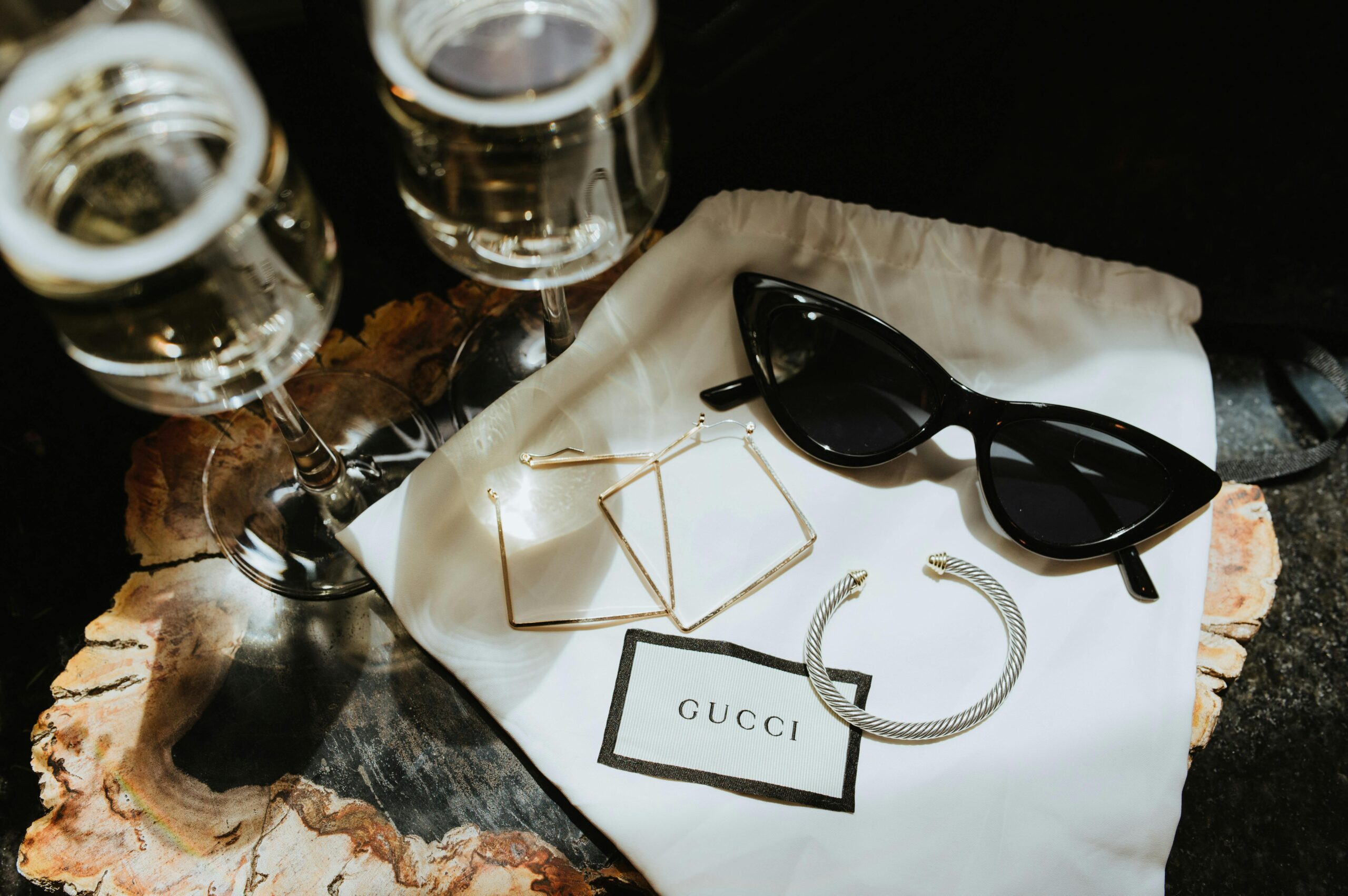 Elegant display of luxury Gucci accessories with champagne glasses.